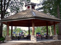 hexagonal picnic shelter at Ebright Creek, supported by six stone and wood columns