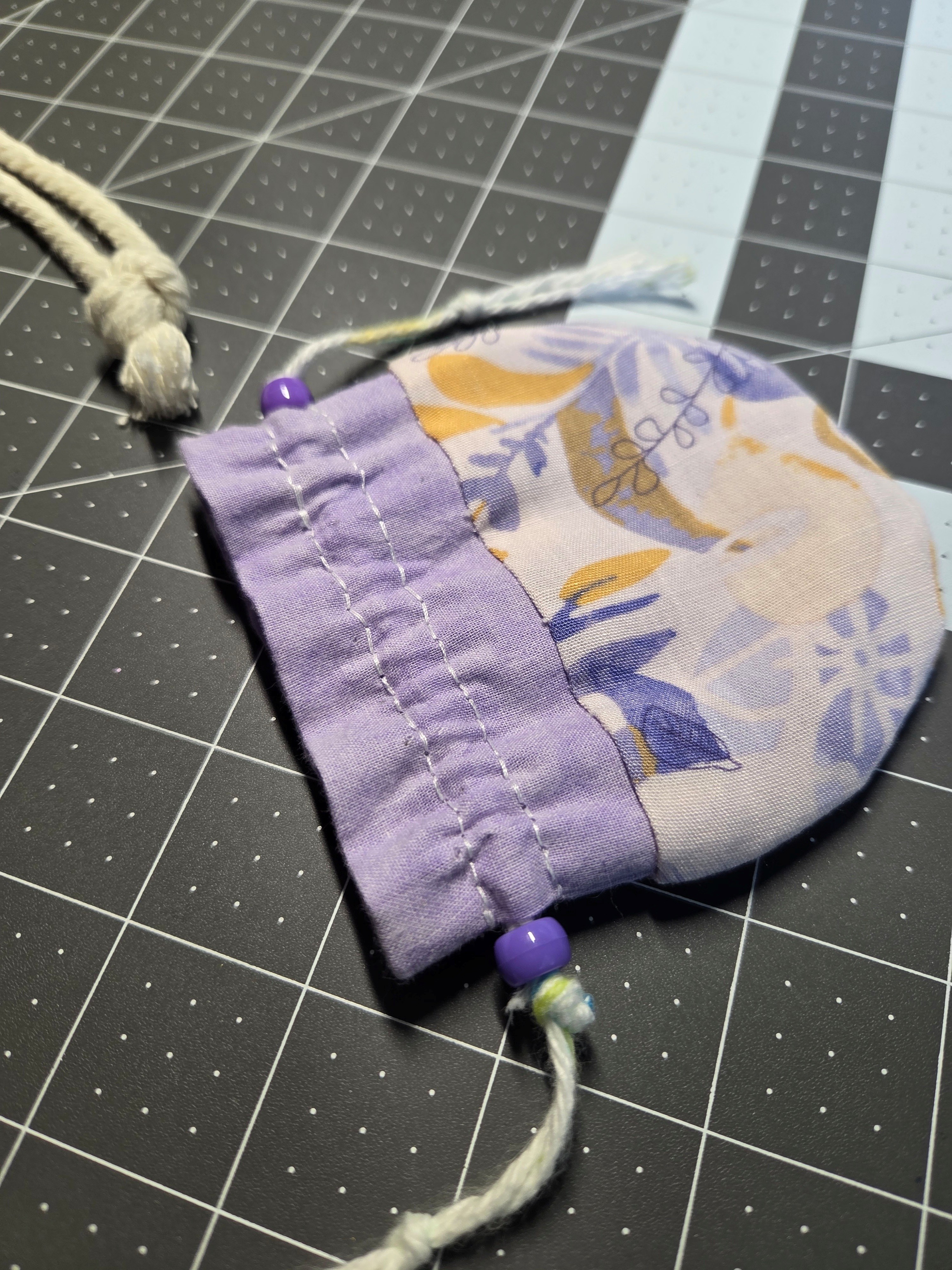 A Hebao pouch, made of colorful, patterned fabric with yarn and bead drawstrings.