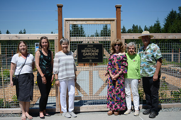 A group of six people pose outside the entrance to the Heritage Garden at Big Rock Park Central in Sammamish.
