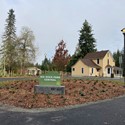 Entrance sign to Big Rock Park Central in parking circle with historic Reard Freed House visible behind