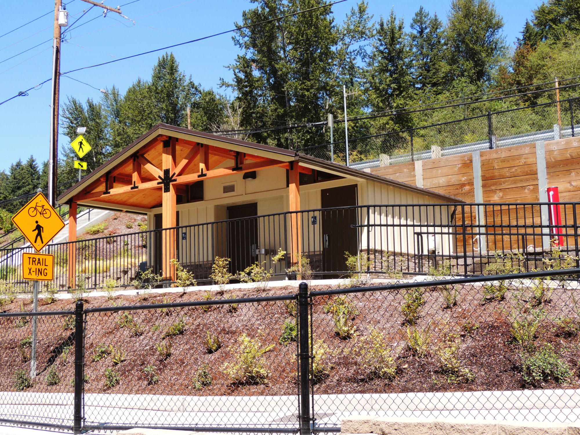 PNW craftsman style multi-room restrooms at Samammish Landing, accessible above a trail by paved ramp, drinking fountain on the building side