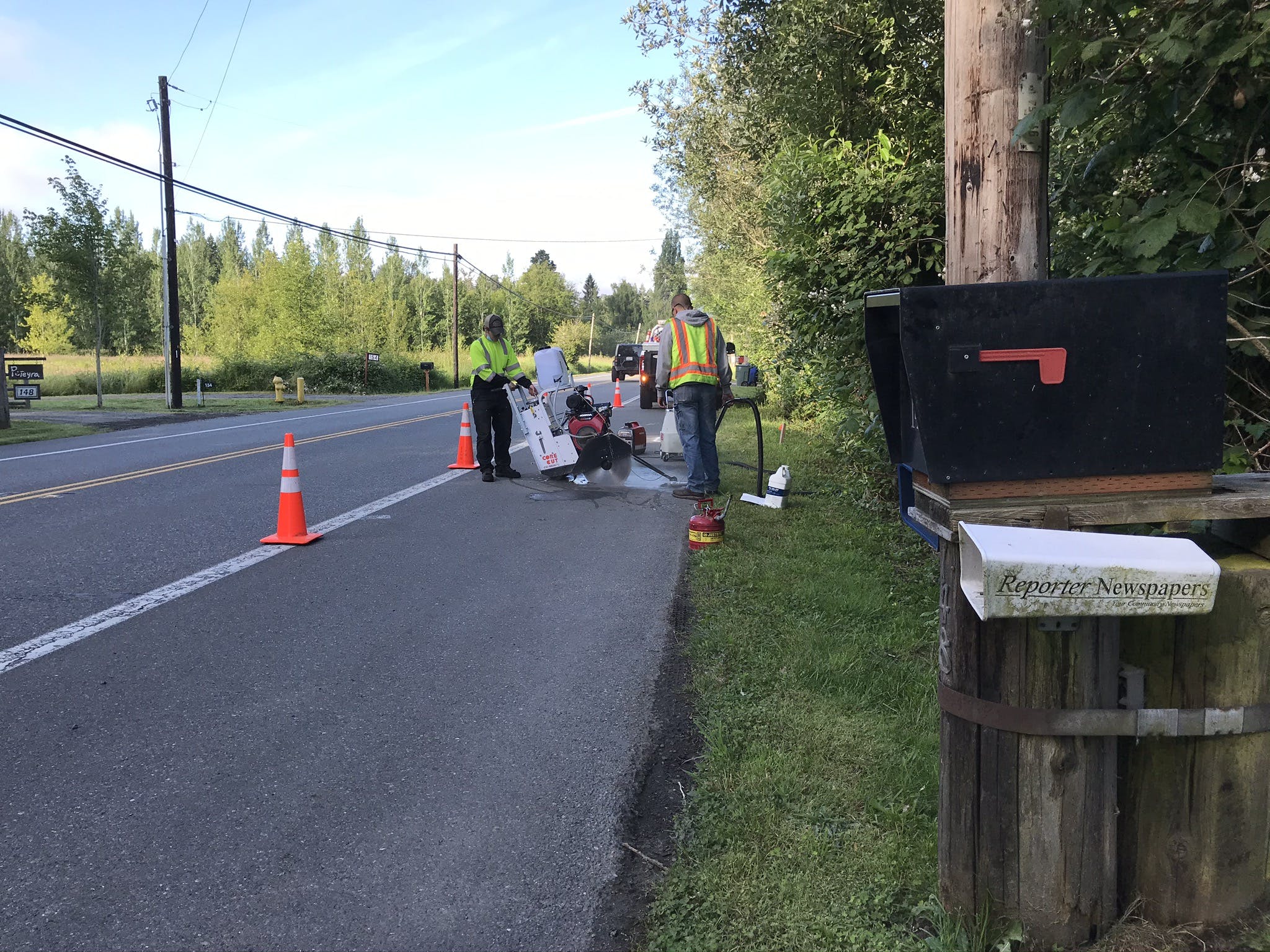 Sammamish Maintenance Crew saw cutting the pavement on the shoulder of the road next to orange cones as part of the Ebright Creek Fish Passage project.