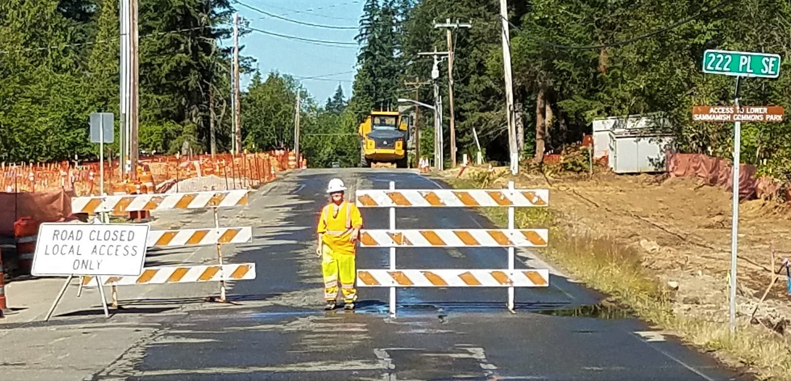 construction worker standing beside road closure