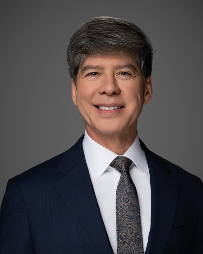 A picture of a man in a suit smiling.