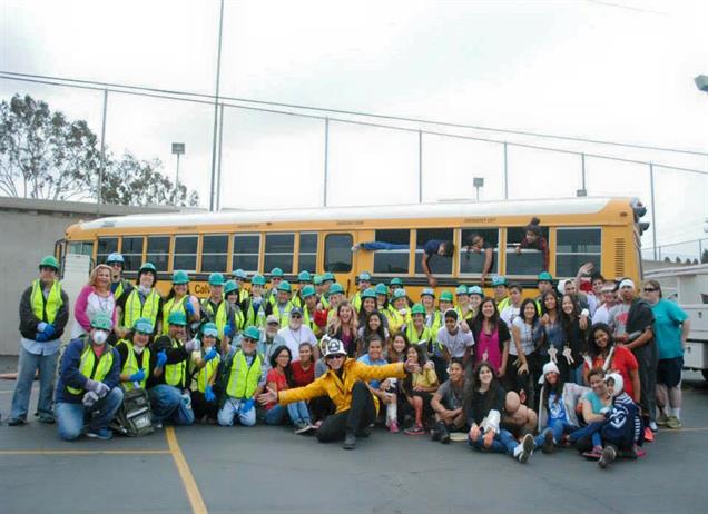 a large group of people wearing hard-hats, members of Sammamish's Community Emergency Response Team, sit in front of a school bus