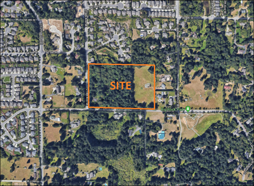 aerial photo with an overlay showing a rectangular site on an area that is part grass and part forest, adjacent to other subdivisions