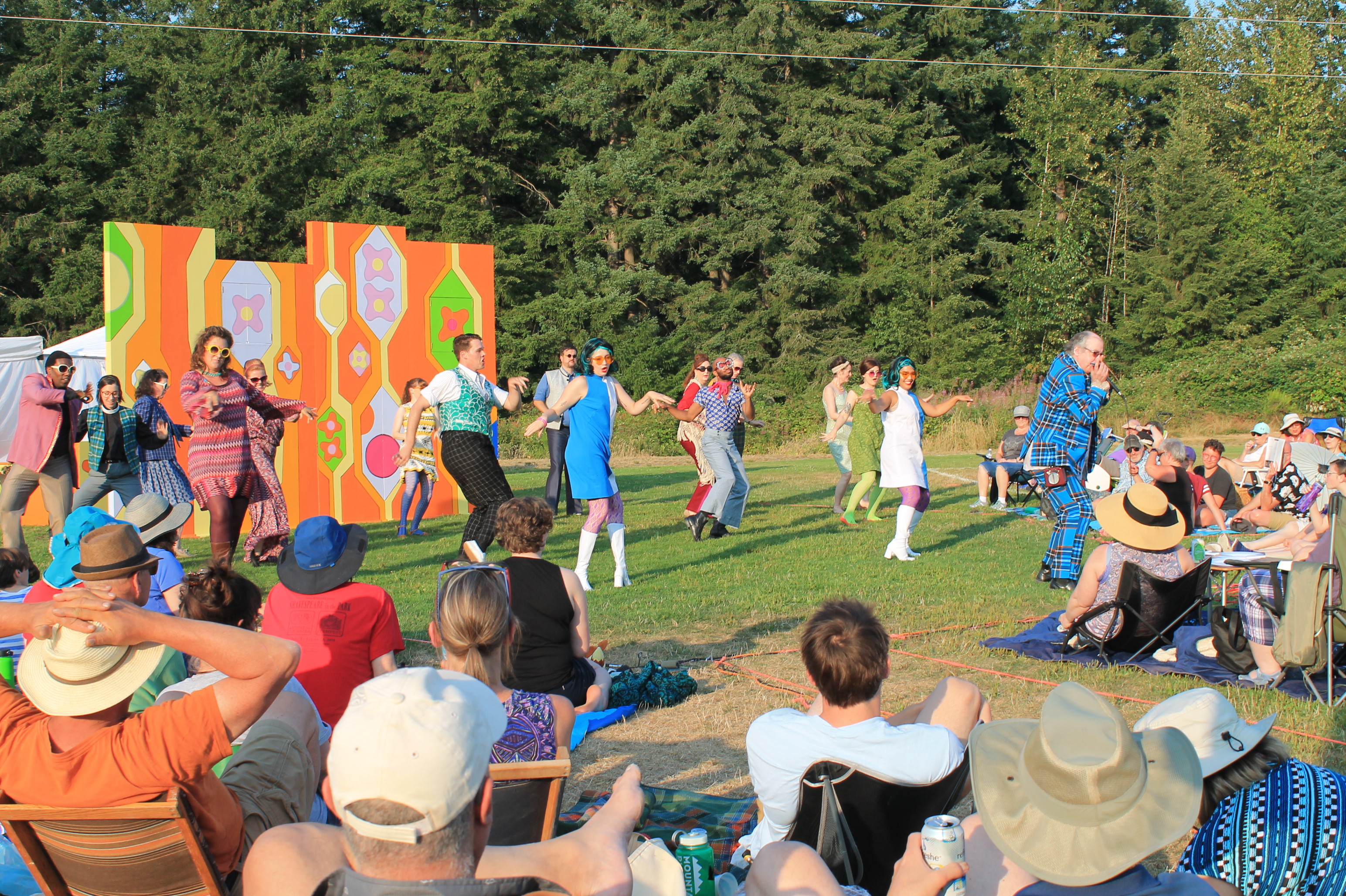 Audience watching people dance at 1960s themed Shakespeare in the Park