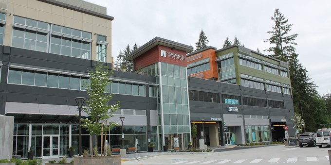large building at The Village at Sammamish Town Center with an entrance to more parking