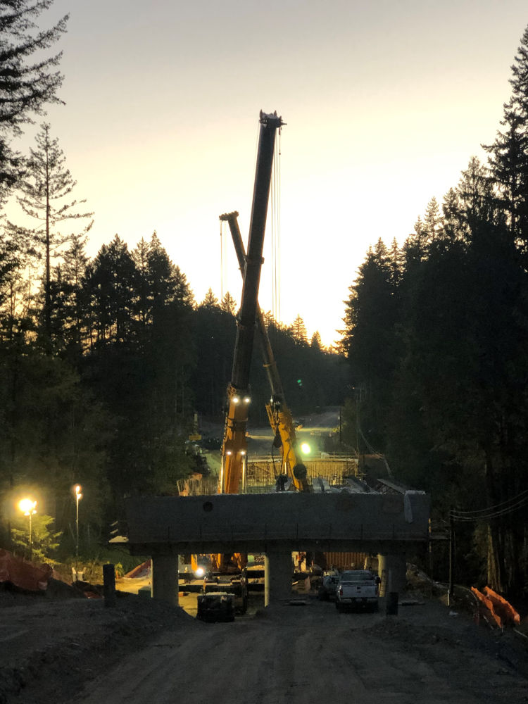 sunset at the bridge construction site as girders are being placed