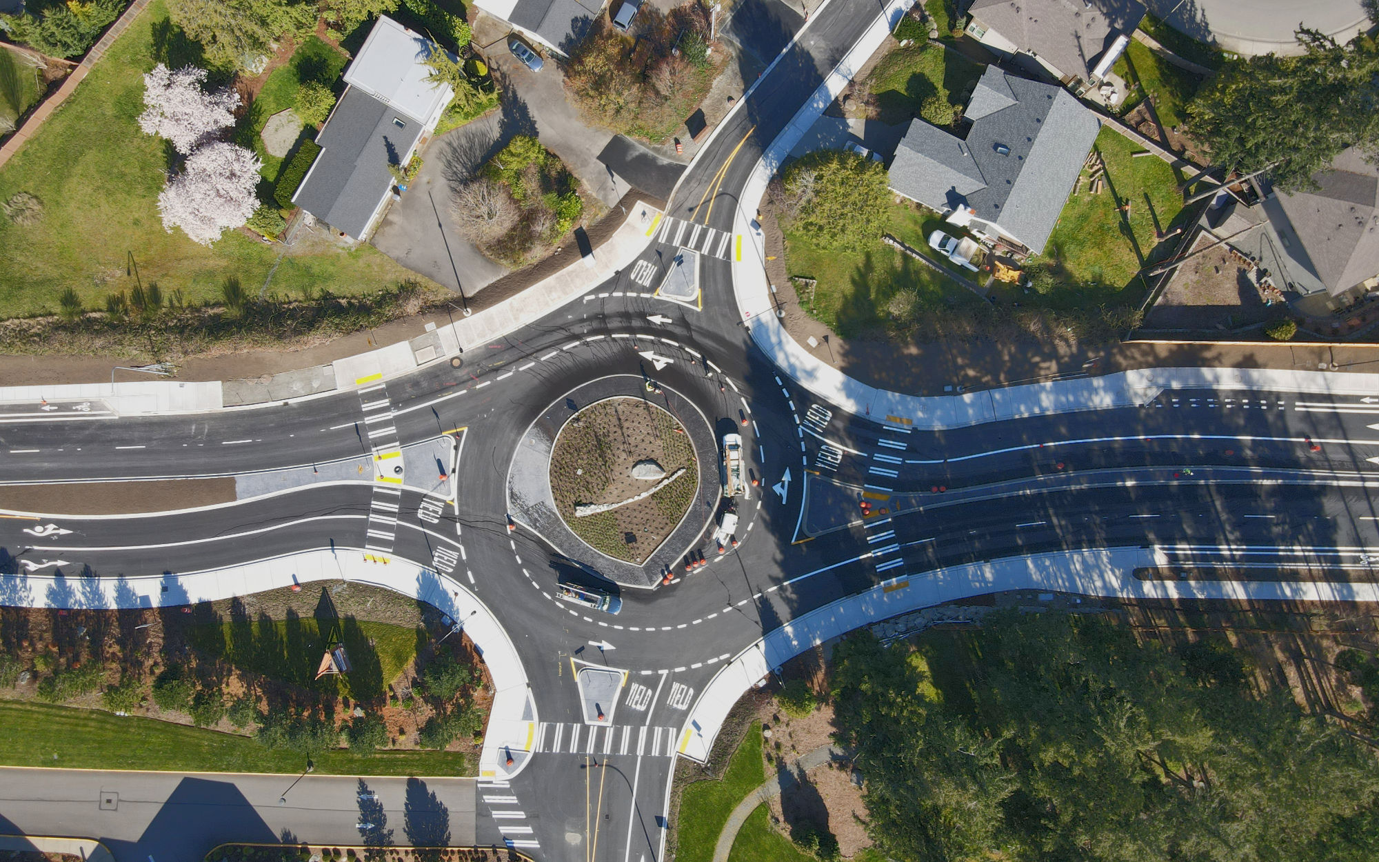 aerial photo of constructed roundabout with four lanes of through traffic and two lanes on the cross-street