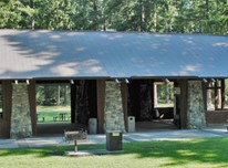 Beaver Lake Pavilion - large open-air wood-frame structure with metal roof and unique triangular-shaped stone support pillars.