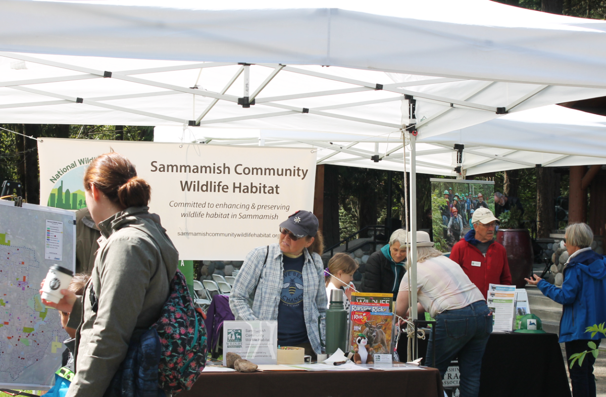 People at booths for Sammamish Community Wildlife Habitat and Washington Trails Association at Earth Day event